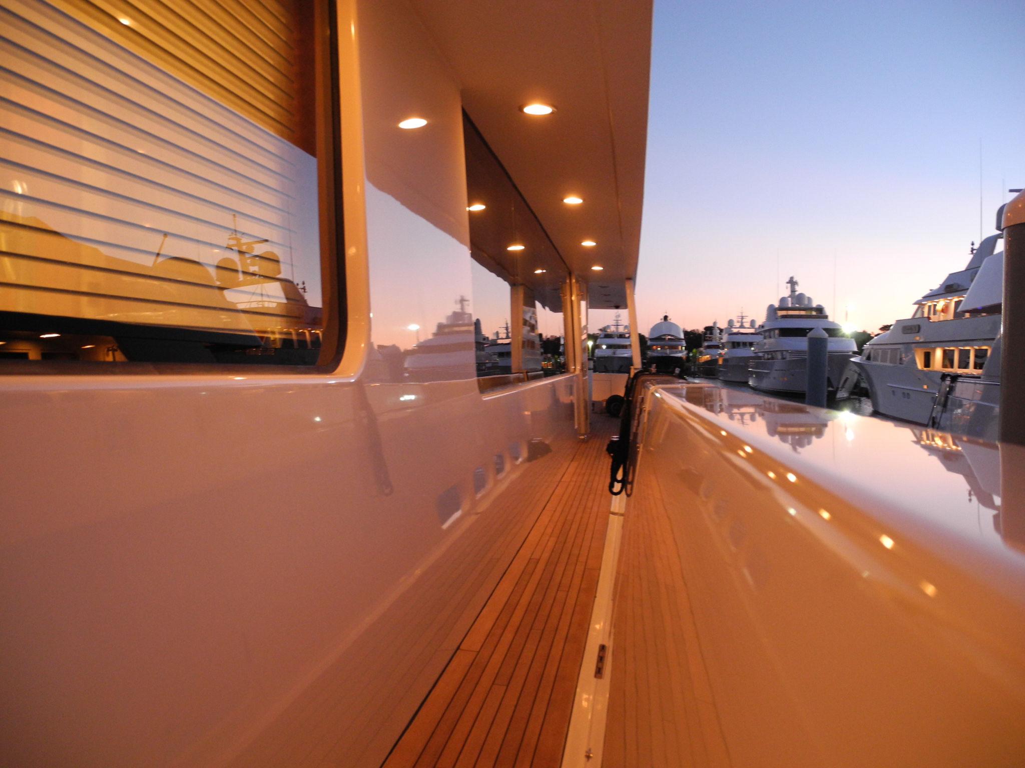 Luxury yacht with clean deck and minimal equipment at sea, highlighting efficient fender storage and modern yacht layout