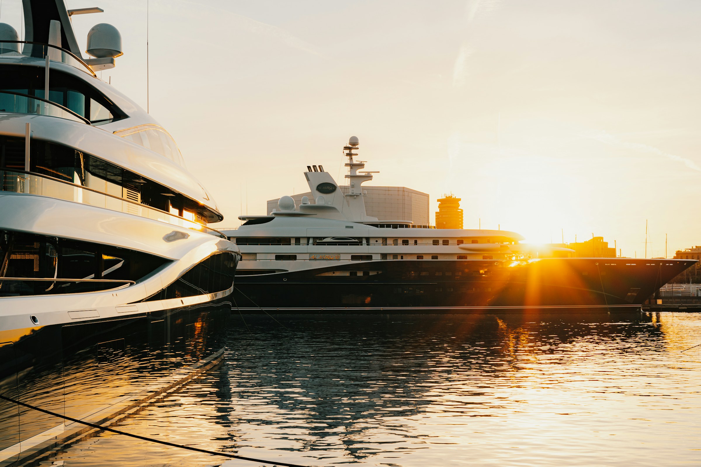 Superyachts moored side by side at sunset